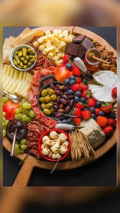 a wooden platter filled with different types of cheeses and fruit on top of it