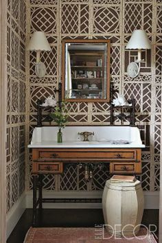 a bathroom with a sink, mirror and lights on the wall next to an area rug