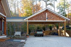 a car is parked in front of a house with a carport and covered porch