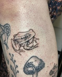 a close up of a person's leg with tattoos on it and a frog