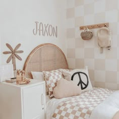 a bed room with a neatly made bed next to a white cabinet and wall decoration