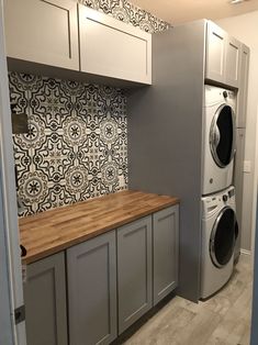 a washer and dryer sitting in a kitchen next to each other on top of cabinets