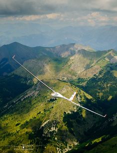 the glider is flying high in the mountains