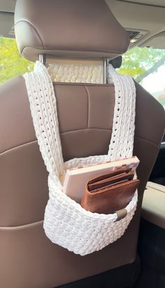 a car seat with a book and wallet hanging from it's back pocket in the backseat