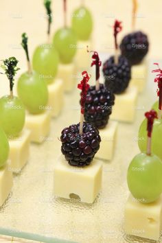 grapes and cheese are arranged on skewers with toothpicks in the form of fruit