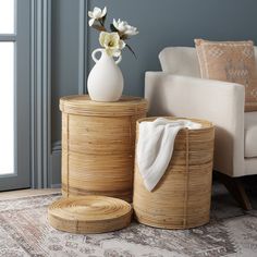 a white vase sitting on top of a wooden table next to two baskets filled with flowers