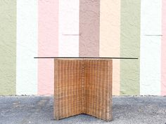 a wicker table sitting in front of a colorful wall