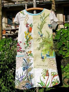 a dress is hanging on a clothes rack in front of some plants and flowers outside