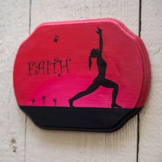 a pink and black painted sign with a woman doing yoga