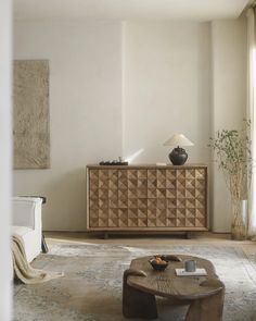 a living room with a coffee table and sideboard