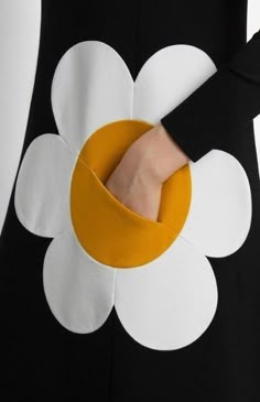 a close up of a person's hand with a flower design on their dress