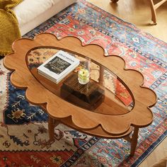 a coffee table with a book on it in the middle of a living room area