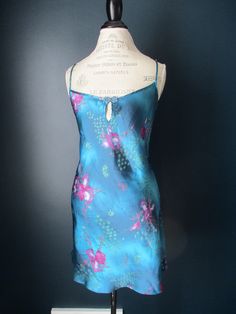 Vintage California Dynasty chemise in jewel tones of green, blue, and purple. Beautiful multi-dimensional looking teal blue fabric with fuschia-purple and green floral pattern. Size Large 100% poly, non adjustable straps. One strap is separating slightly at the seam as can be seen in pictures. Blue Summer Night Chemise, Blue Chemise For Summer Nights, Summer Night Blue Chemise, 90s Lingerie, Baddie Dresses, Lingerie Nightgown, Teal Top, Multi Dimensional, Vintage California