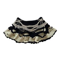 a black and white crocheted skirt with lace on the bottom is shown in front of a white background