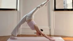 a woman is practicing yoga in an empty room