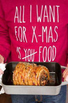 a person in a red shirt is holding a tray with food on it and the words all i want for x - mas is you food