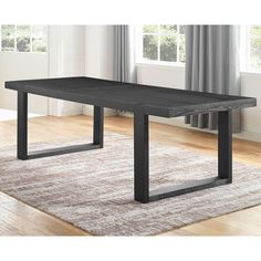 a black table sitting on top of a hard wood floor next to a white rug