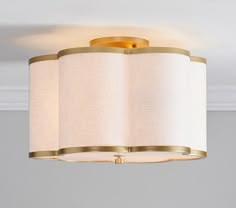 a light that is on in a room with a white wall behind it and two lamps hanging from the ceiling