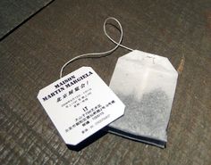 a white tag sitting on top of a piece of paper next to a string attached to it