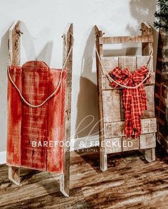 two wooden sleds with red plaid bows on them