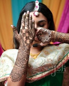 a woman holding her hands up with henna on it