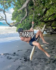 a man hanging from a rope on top of a tree near the ocean with words reading charlie