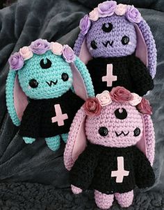 three crocheted stuffed animals sitting on top of a gray blanket next to each other