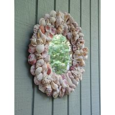 a wreath made out of seashells hangs on the wall