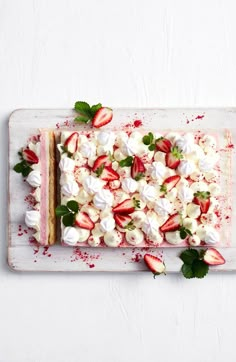 there is a cake with strawberries and whipped cream on the top, along with mint leaves