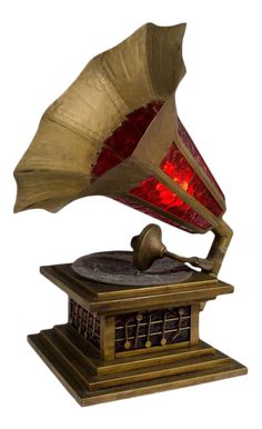 an antique phonograph with red lights on it's head and body, sitting on top of a wooden stand