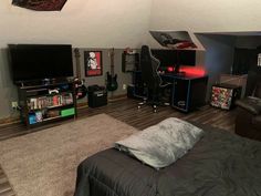 a bedroom with a bed, desk and television in it's corner area on the floor