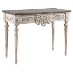 an antique white desk with black marble top