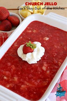 a white dish filled with food next to some strawberries and other fruit on the table