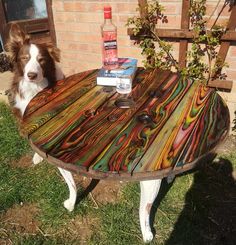 a dog is sitting at a table made out of wood and has a bottle on it