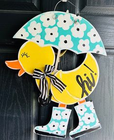 a door hanger with an umbrella and rubber ducky boots hanging from it's side