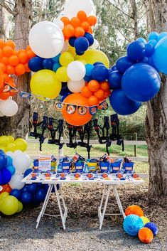 an outdoor birthday party with balloons and decorations