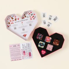 a heart shaped box filled with cards and dices next to an open card game