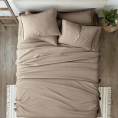 an overhead view of a bed with brown sheets and pillows