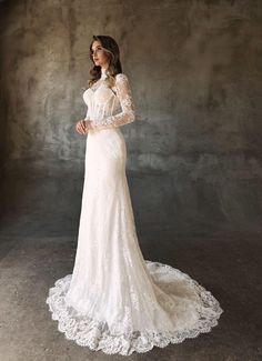 a woman in a white wedding dress with long sleeves and an open neckline is posing for the camera