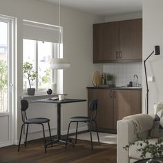 a living room filled with furniture next to a kitchen and dining room table in front of a window