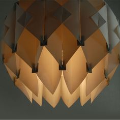 a modern light fixture with geometric shapes hanging from it's sides and the lights turned on