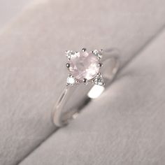 ◆The ring draws inspiration from the polaris. Hand-finished in Sterling sliver, this piece features a round shaped pink quartz. Clear zirzons decorate around the main stone. An extremely simple celestial ring that you cannot miss. ◆ Production Description: Main stone Type: Pink Quartz Main Stone Shape: Round Main Stone Size: 6*6mm Side stone: CZ Metal: 925 Sterling silver - Other options available in the drop down menu ◆ Customization: √Free for Add Engraving √Other Metal Type Available √Other G Rose Engagement Ring Vintage, Pink Quartz Ring, Rose Quartz Ring Engagement, Promise Rings Simple, July Birthstone Ring, Green Sapphire Ring, Celestial Ring, Minimalist Engagement Ring, London Blue Topaz Ring