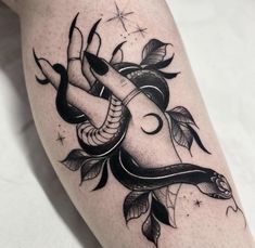 a black and white tattoo on the leg of a woman's legs with an image of a snake