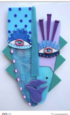 an art piece made out of colored paper with eyes and fish on the bottom half