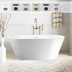 a white bath tub sitting on top of a wooden floor next to two vases