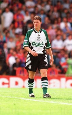 a man standing on top of a field next to a soccer ball in front of a crowd