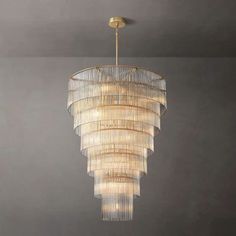 a chandelier hanging from the ceiling in a room with grey walls and flooring