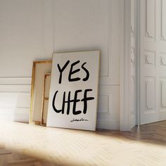 there is a sign that says yes chef on the floor next to an empty frame