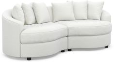 a white couch with lots of pillows on it's back and side cushions that are curved