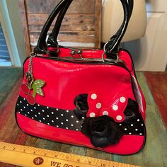 Disney Red Vinyl Purse With Black Vinyl Handles, Black With White Polka Dots, Satin Black Flowers, Two Metal Charms, One Cherries And One Heart. Snap Top Closure. Zipper Pocket Inside. 12”W X 9”H X 4.5”D. New With Tags. Excellent Condition. Nightmare Before Christmas Purse, Disneyland Backpack, Minnie Mouse Bag, Heart Snap, Nightmare Before Christmas Backpack, Vinyl Purse, Mickey Mouse Backpack, Minnie Mouse Backpack, Disney Vans